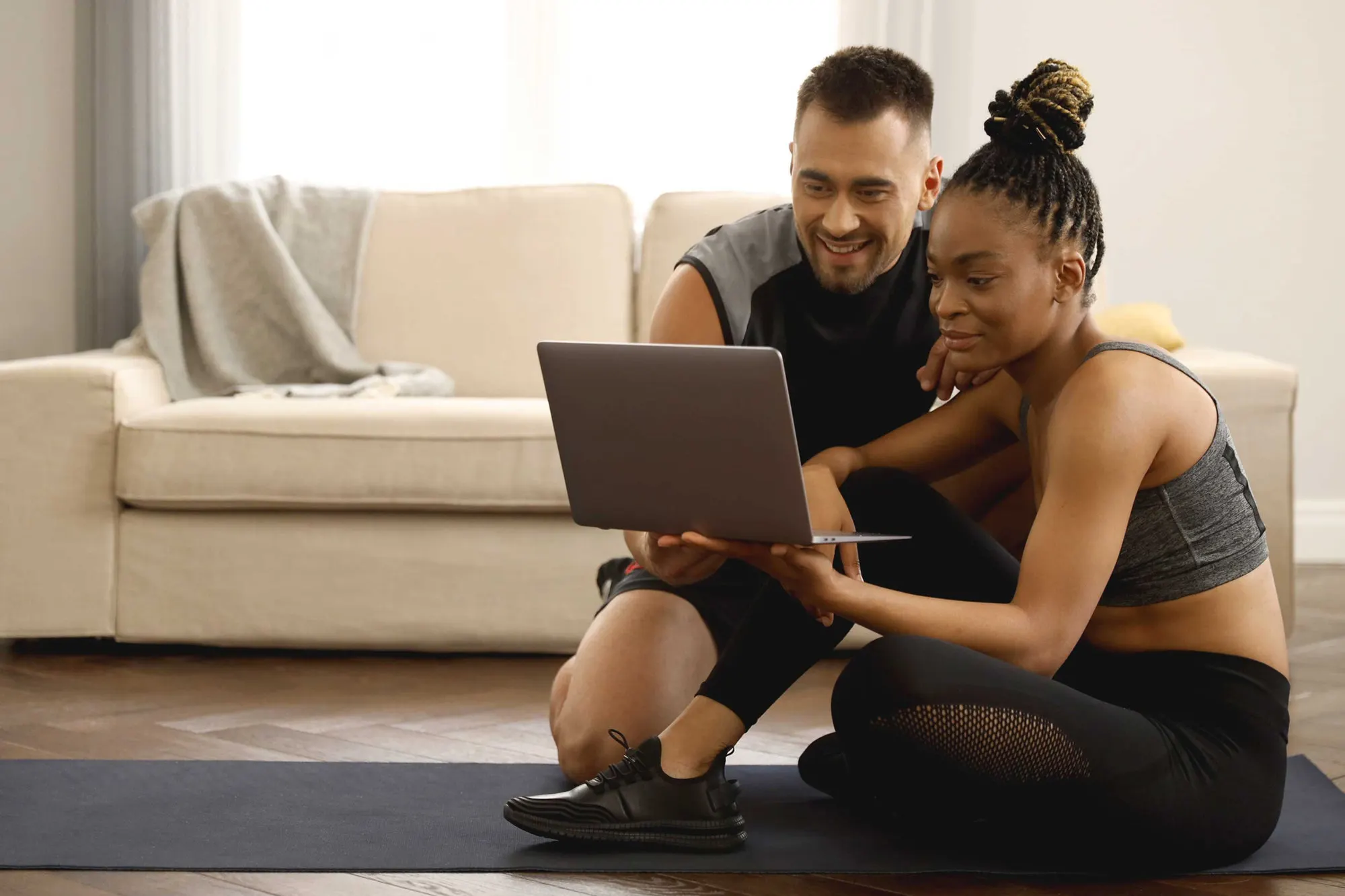 Duas pessoas colaborando diante de um notebook